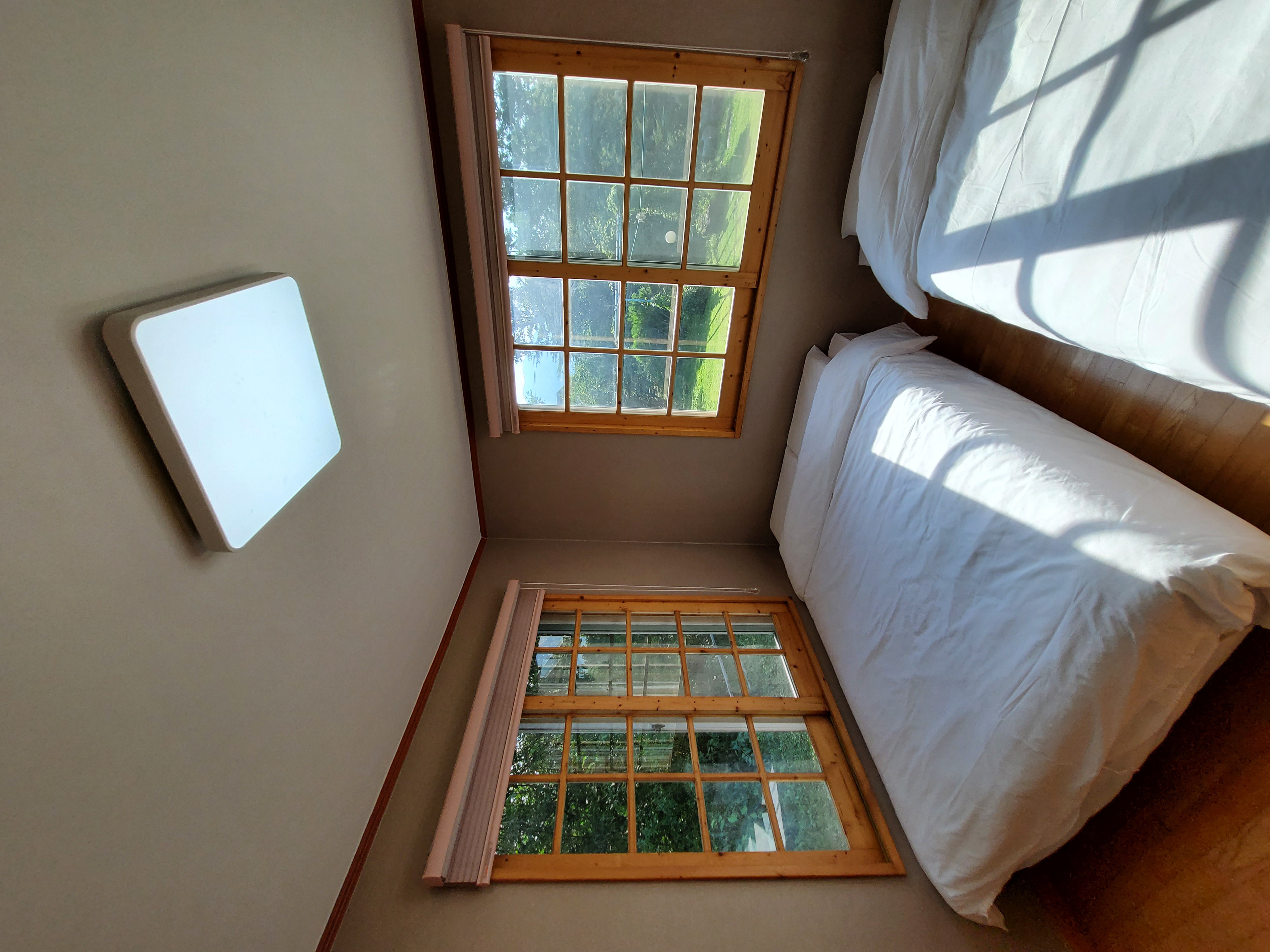 설악팜 스테이 침실, 트윈 침대와 넓은 창문으로 자연 풍경이 보이는 아늑한 공간